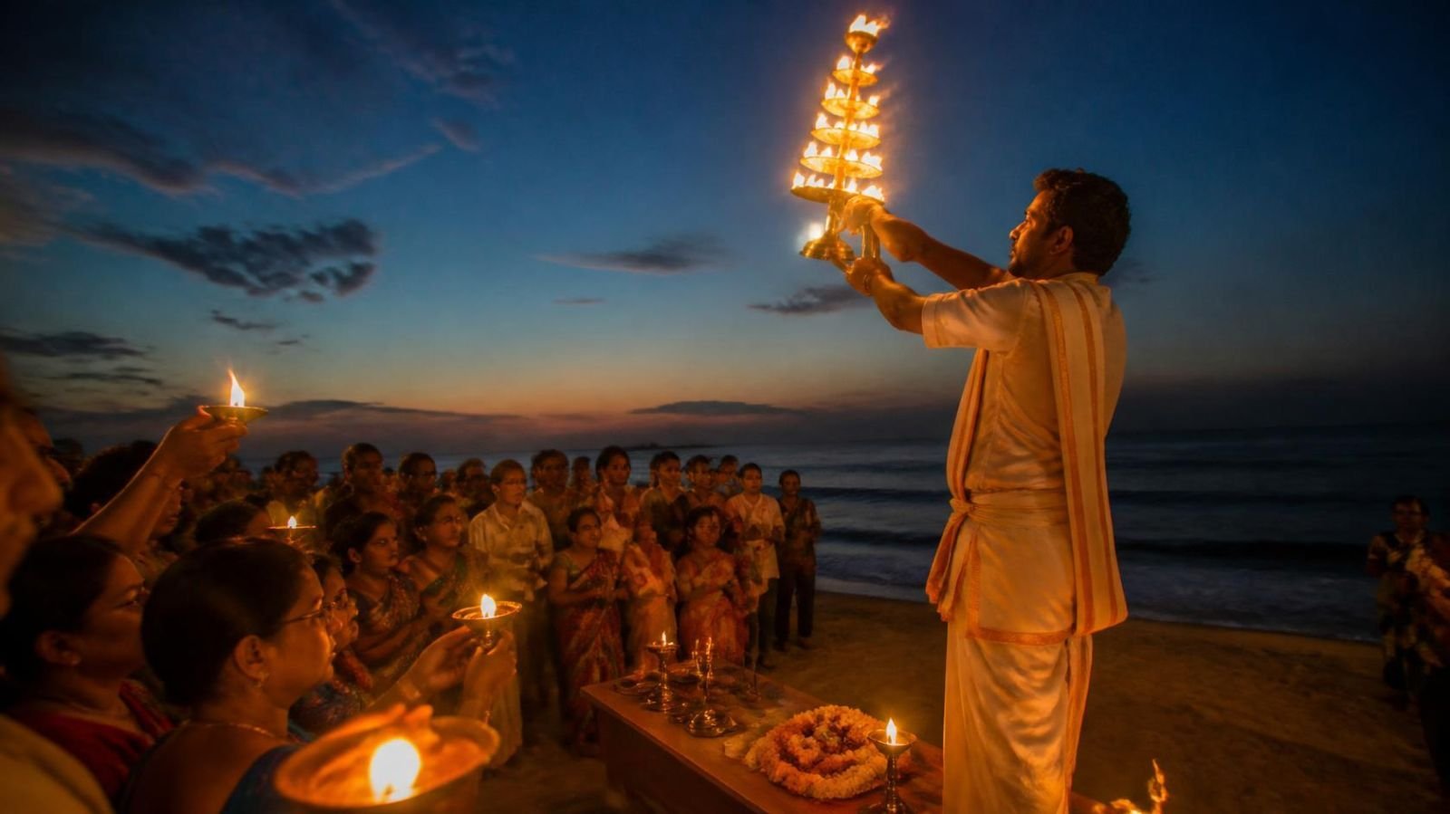 Evening aarti with diyas on the beach at Gangasagar